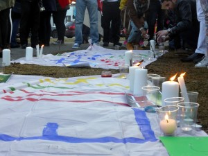 À la fin de l'événement, chaque personne a pu déposer des bougies auprès des drapeaux commémoratifs. Crédit photo : Anastassia Depauld