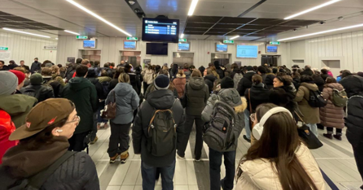 Une foule compacte d’usagers attend devant les ascenseurs à la station du REM Édouard-Montpetit, en pleine heure de pointe. © Alexis Thériault